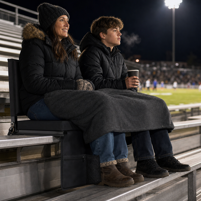 A mother and her teenager sitting in Full Game Chairs under a blanket on a cold night in the stands