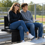 A mother and her teenager seated in Full Game Chairs on a bleacher watching a daytime game